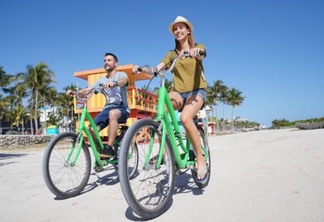 Casal andando de bicicleta por South Beach em Miami