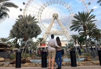 Casal em frente à roda-gigante The Wheel em Orlando