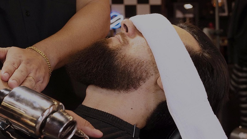 Serviço com toalha quente da barbearia de brasileiros Ultimate Cave em Orlando