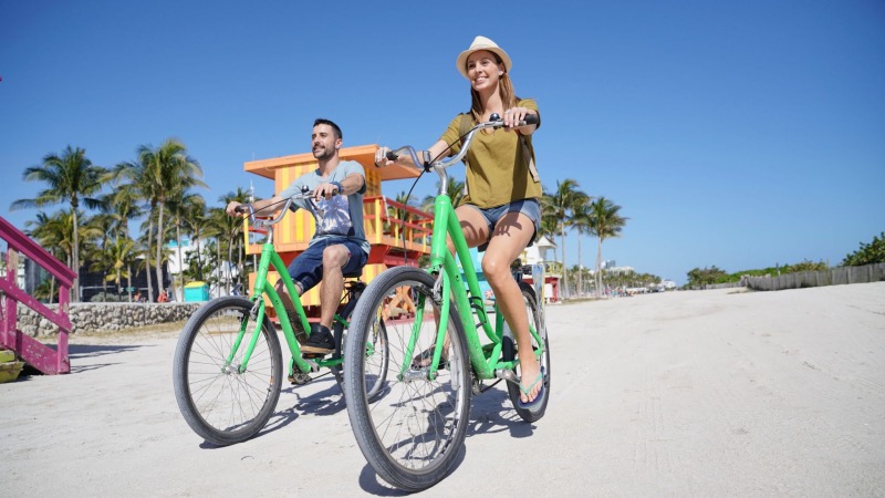 Casal andando de bicicleta por South Beach em Miami